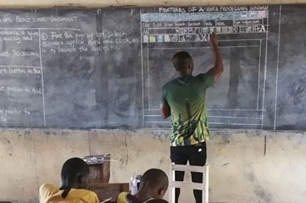 Учитель информатики из Ганы рисует компьютер мелом на доске - слайд 
